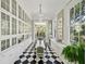 Elegant dining room with checkered floors, built-in cabinets, and access to outdoor balcony, perfect for entertaining at 172 Tradd St, Charleston, SC 29401