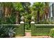 Ornate gated entrance surrounded by lush greenery and mature palm trees at 172 Tradd St, Charleston, SC 29401