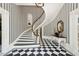 Elegant foyer showcasing a curved staircase, striped wallpaper, and black and white checkered flooring at 172 Tradd St, Charleston, SC 29401