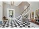 Grand foyer with a curved staircase, elegant wallpaper, and black-and-white checkered flooring at 172 Tradd St, Charleston, SC 29401
