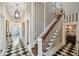 Hallway with bold black and white checkered flooring, striped wallpaper, and staircase at 172 Tradd St, Charleston, SC 29401