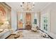 Elegant formal living room featuring a crystal chandelier, stylish decor, and lots of natural light at 172 Tradd St, Charleston, SC 29401