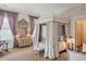 Ornate main bedroom with four poster bed, patterned wallpaper, and beautiful accents at 172 Tradd St, Charleston, SC 29401