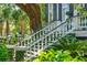 Exterior stairway leads to the home's entrance surrounded by lush greenery at 172 Tradd St, Charleston, SC 29401
