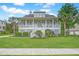 Inviting two-story home featuring a spacious front porch, well-manicured lawn, and lush tropical landscaping at 1776 W Canning Dr, Mount Pleasant, SC 29466