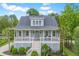 Charming home featuring a welcoming front porch, manicured landscaping, and a light blue front door at 1776 W Canning Dr, Mount Pleasant, SC 29466