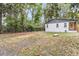 Spacious backyard with mature trees, detached garage, and partially fenced yard at 1790 Brockington Ave, Charleston, SC 29407