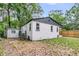 View of home's exterior and detached garage from the spacious, leaf-strewn backyard at 1790 Brockington Ave, Charleston, SC 29407