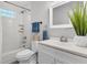 A bright bathroom features a white vanity, tiled shower with glass block window, and modern fixtures at 1790 Brockington Ave, Charleston, SC 29407