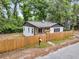 Home with a wooden fence and covered porch, surrounded by mature trees at 1790 Brockington Ave, Charleston, SC 29407
