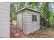 Exterior shot of a metal storage shed with a door and window, surrounded by trees and leaves at 1790 Brockington Ave, Charleston, SC 29407
