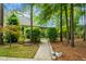 Backyard view featuring a well-maintained lawn, a gated patio area, mature trees, and thoughtful landscaping at 184 Angora Way, Summerville, SC 29485