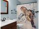 Charming bathroom with a turtle-themed shower curtain, wood vanity, and soft blue walls at 184 Angora Way, Summerville, SC 29485
