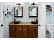 Bathroom with dual sinks, bronze fixtures, wood cabinets, and open door showing toilet at 184 Angora Way, Summerville, SC 29485