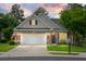 Charming brick home featuring a two-car garage, manicured lawn, and a welcoming front porch with rocking chairs at 184 Angora Way, Summerville, SC 29485
