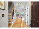 Inviting foyer with gleaming hardwood floors, staircase with wood railing and views into the living room at 184 Angora Way, Summerville, SC 29485