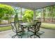 Inviting screened porch with outdoor dining set and views of the landscaped backyard and lush greenery at 184 Angora Way, Summerville, SC 29485