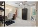 Carpeted home office space with a ceiling fan, black cabinet, neutral walls, and views into an ensuite bathroom at 188 Midland Parkway # 110, Summerville, SC 29485