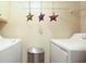 Functional laundry room with a trash bin, hanging star decorations, and modern washer and dryer at 188 Midland Parkway # 110, Summerville, SC 29485