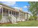 Lush backyard with a screened porch, stairs, seating, and mature trees, perfect for outdoor living and entertaining at 1985 Shields Ln, Mount Pleasant, SC 29466