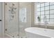 Modern bathroom featuring a soaking tub and a glass-enclosed shower with marble walls at 1985 Shields Ln, Mount Pleasant, SC 29466