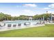 Community pool with lounge chairs, tables, and shade umbrellas on sunny day at 1985 Shields Ln, Mount Pleasant, SC 29466