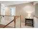 Second-floor hallway featuring oak railing, a console table with a lamp, and views of windows at 1985 Shields Ln, Mount Pleasant, SC 29466