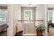 Upstairs hallway featuring neutral carpet, wood railing, natural light, and decor at 1985 Shields Ln, Mount Pleasant, SC 29466