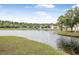 Community pond with grassy bank, houses, and mature trees on sunny day at 1985 Shields Ln, Mount Pleasant, SC 29466