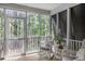 Charming screened porch with white rocking chairs and views of the lush surroundings at 1985 Shields Ln, Mount Pleasant, SC 29466