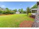 Large backyard featuring manicured lawn, mature trees, and a detached garage at 2017 Woodland Shores Rd, Charleston, SC 29412