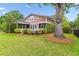 Spacious backyard with mature trees, screened-in porch, and lush green lawn at 2017 Woodland Shores Rd, Charleston, SC 29412