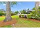 Beautiful backyard featuring a lush lawn, mature trees, and a charming screened-in porch at 2017 Woodland Shores Rd, Charleston, SC 29412