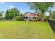 Expansive backyard featuring lush green lawn, mature trees, and a black metal fence at 2017 Woodland Shores Rd, Charleston, SC 29412