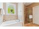 Bright bathroom features a soaking tub with tile accents and a glass-enclosed shower at 2017 Woodland Shores Rd, Charleston, SC 29412
