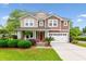 Beautiful two-story home featuring well-manicured lawn, red door, and attached two-car garage at 2017 Woodland Shores Rd, Charleston, SC 29412
