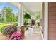 Spacious front porch with stone-detailed pillars, hanging ferns, and comfortable rocking chairs at 2017 Woodland Shores Rd, Charleston, SC 29412