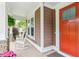 Inviting front porch featuring cozy rocking chairs, decorative plants, and a bright red door at 2017 Woodland Shores Rd, Charleston, SC 29412