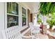 Cozy front porch view featuring rocking chairs, hanging ferns, and blooming flowers at 2017 Woodland Shores Rd, Charleston, SC 29412
