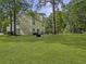 Expansive backyard featuring lush green grass, mature trees, and an open space for recreation at 206 Challis Ct, Goose Creek, SC 29445