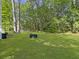Spacious backyard with lush green grass, mature trees, and an area perfect for outdoor activities at 206 Challis Ct, Goose Creek, SC 29445