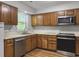 Well-lit kitchen features classic wood cabinets, stainless steel appliances, and lots of natural light at 206 Challis Ct, Goose Creek, SC 29445