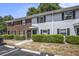 Exterior view of townhomes featuring brick and gray siding, complemented by lush green landscaping and ample parking at 21 Rivers Point Row # 3C, Charleston, SC 29412
