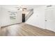 Spacious living room showcases modern wood-look floors, a ceiling fan, natural light and adjacent stairwell at 21 Rivers Point Row # 3C, Charleston, SC 29412