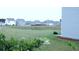 Serene backyard featuring a pond view, surrounded by lush greenery and peaceful neighborhood homes at 224 Coral Sunset Way, Summerville, SC 29486