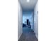 Hallway with white walls and trim, with an open view of a living area with dark gray wood flooring at 224 Coral Sunset Way, Summerville, SC 29486
