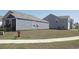 Neighborhood street scene with a sidewalk, grassy area, and newly built homes in the background at 224 Coral Sunset Way, Summerville, SC 29486