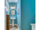 Charming powder room featuring blue walls, a pedestal sink, and stylish decor, offering a fresh appeal at 240 Woodbrook Way, Moncks Corner, SC 29461