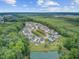 An aerial view showing a neighborhood surrounding a pond, backed by a forest canopy at 249 Old Savannah Dr, Goose Creek, SC 29445