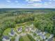 Aerial view of a community surrounded by lush green forest, featuring a serene pond at 249 Old Savannah Dr, Goose Creek, SC 29445